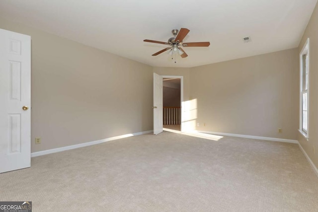 empty room with ceiling fan and light carpet