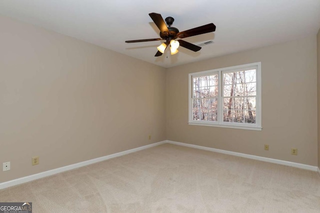 spare room featuring light carpet and ceiling fan