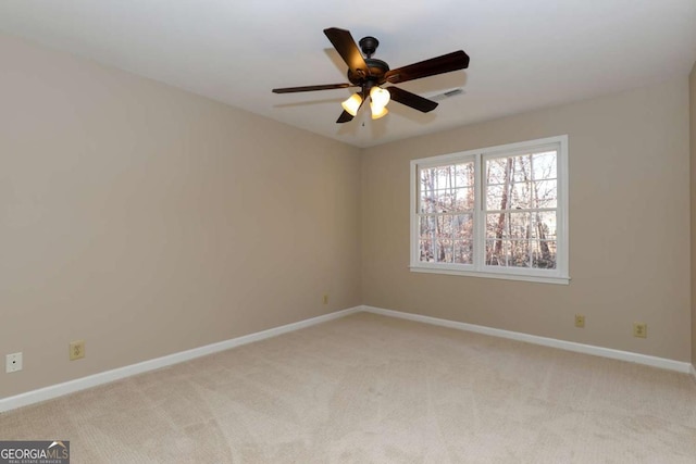 empty room featuring baseboards, ceiling fan, visible vents, and light colored carpet