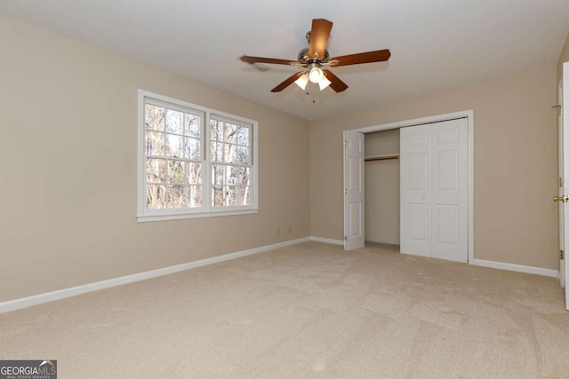 unfurnished bedroom featuring baseboards, ceiling fan, a closet, and light colored carpet