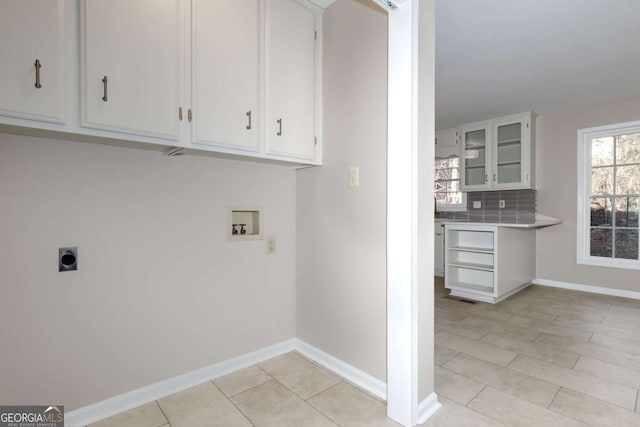 laundry area featuring baseboards, cabinet space, washer hookup, light tile patterned floors, and hookup for an electric dryer