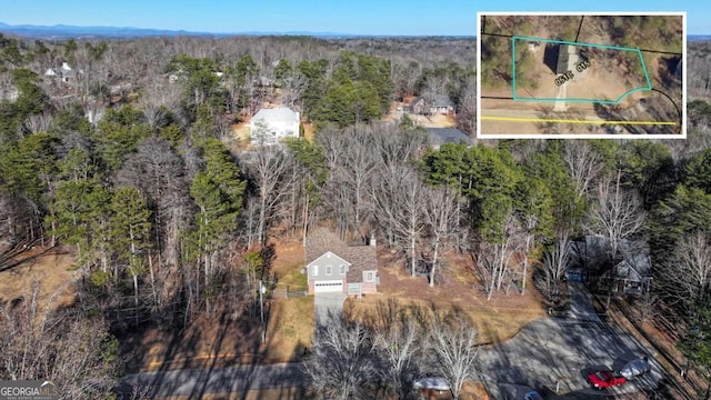 birds eye view of property featuring a wooded view