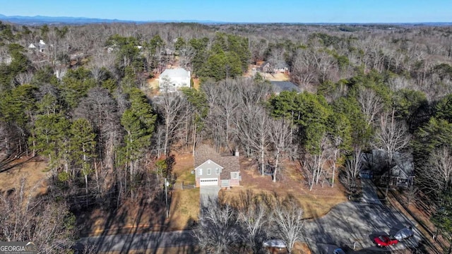 drone / aerial view featuring a wooded view