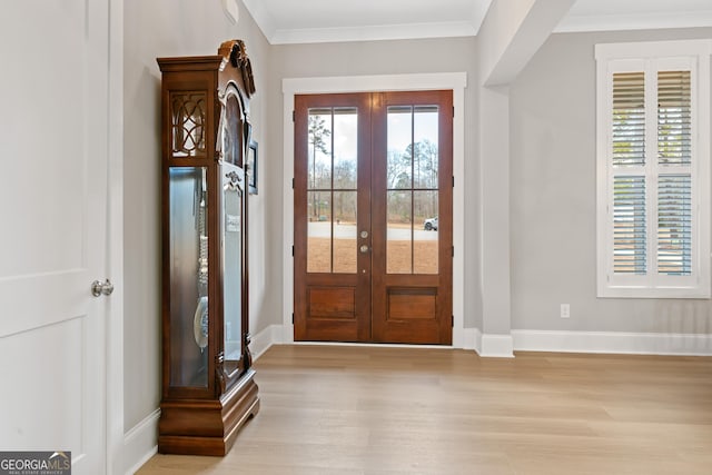 entrance foyer featuring light hardwood / wood-style flooring, french doors, and crown molding