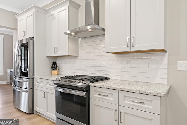 kitchen with white cabinetry, appliances with stainless steel finishes, wall chimney exhaust hood, and tasteful backsplash