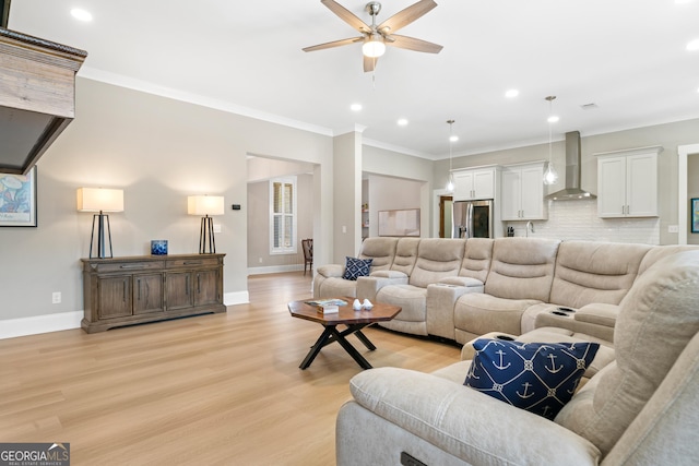 living room featuring ceiling fan, ornamental molding, and light wood-type flooring