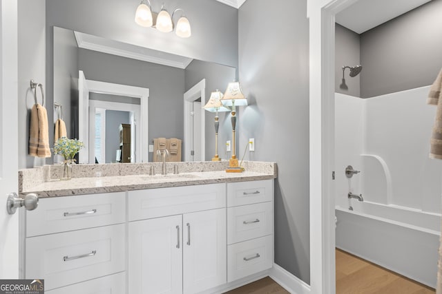 bathroom with vanity, hardwood / wood-style flooring, bathtub / shower combination, and ornamental molding