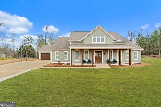 view of front of house with a porch, a garage, and a front lawn