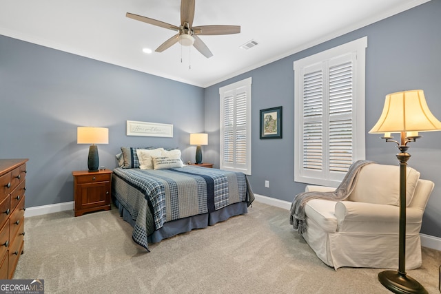 carpeted bedroom featuring ceiling fan and crown molding