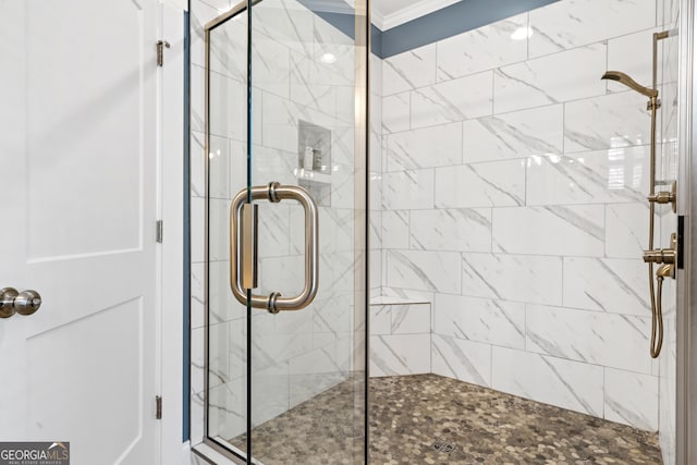 bathroom with a shower with shower door and ornamental molding