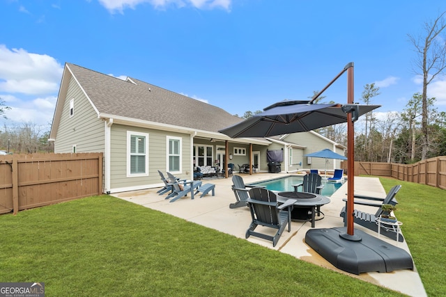 back of house featuring a patio area, a fenced in pool, a yard, and an outdoor fire pit