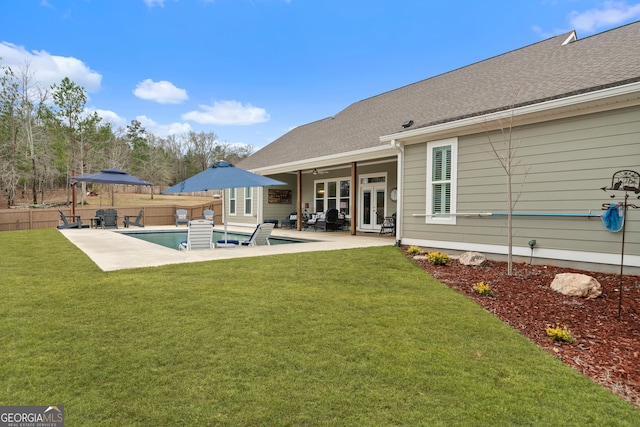 rear view of house featuring a lawn, a gazebo, a swimming pool with hot tub, and a patio