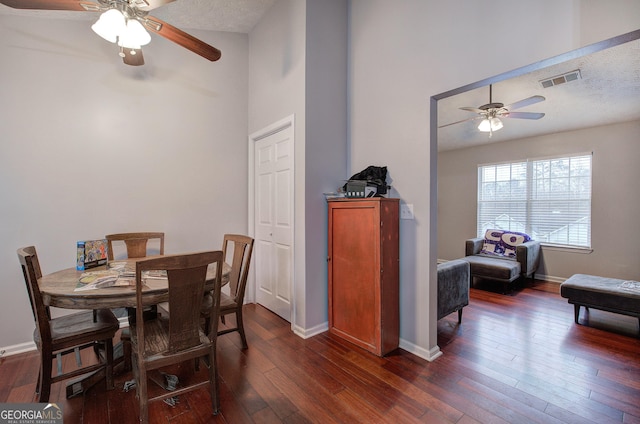 dining area with dark wood-type flooring, a textured ceiling, and ceiling fan