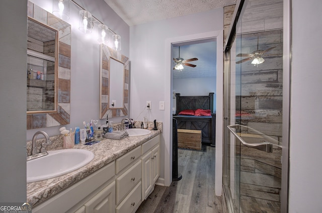 bathroom featuring an enclosed shower, a textured ceiling, wood-type flooring, vanity, and ceiling fan