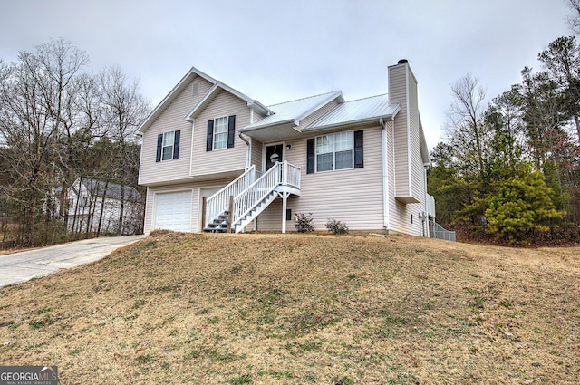 split level home featuring a garage and a front lawn