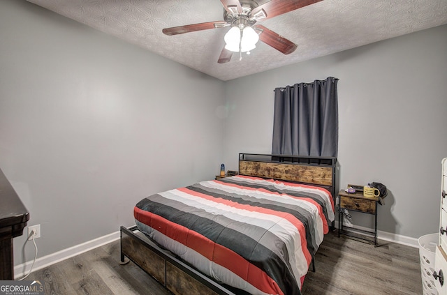 bedroom featuring ceiling fan, a textured ceiling, and dark hardwood / wood-style floors