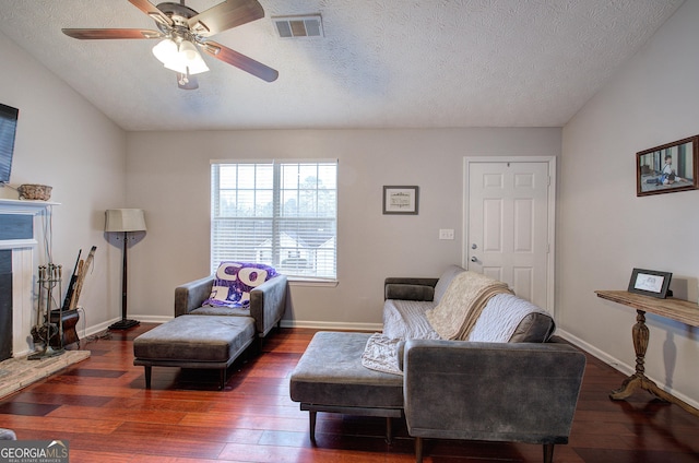 sitting room with ceiling fan, dark hardwood / wood-style floors, and a textured ceiling