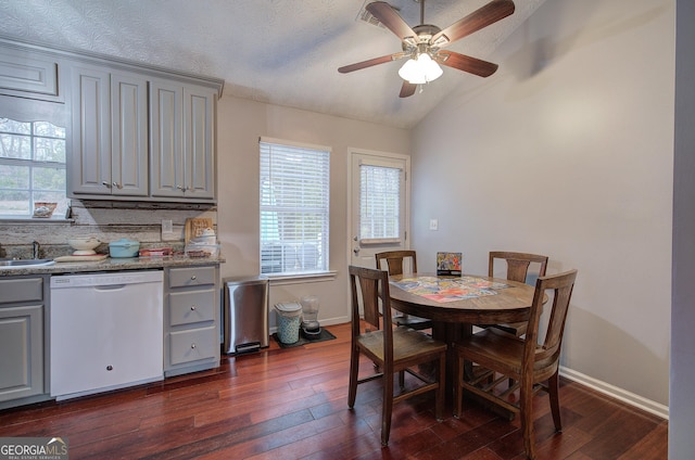 dining area featuring ceiling fan, dark wood-type flooring, a textured ceiling, and lofted ceiling