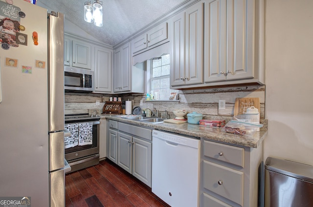 kitchen featuring appliances with stainless steel finishes, a textured ceiling, gray cabinetry, sink, and dark hardwood / wood-style flooring