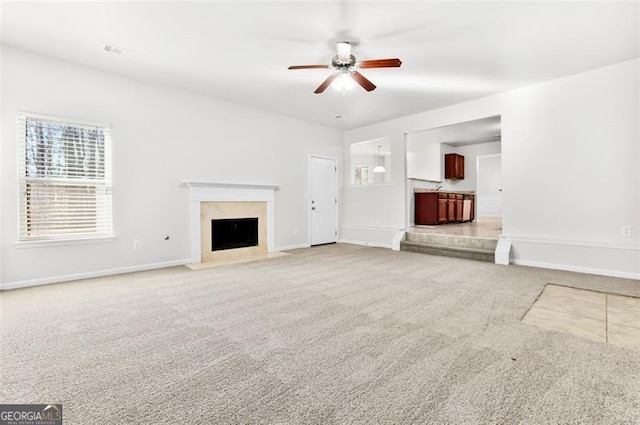 unfurnished living room featuring ceiling fan and carpet floors