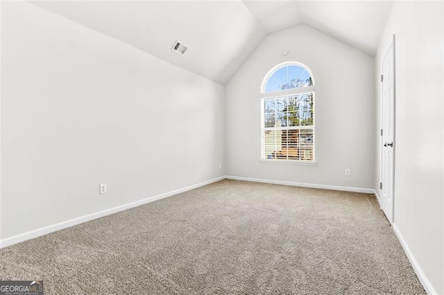 empty room with carpet floors and lofted ceiling