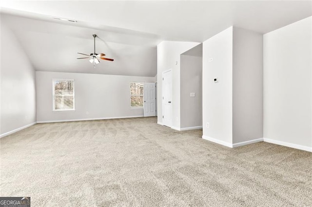 unfurnished living room with light colored carpet, vaulted ceiling, and ceiling fan