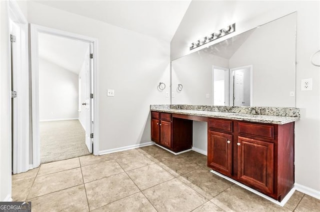 bathroom with tile patterned flooring, vanity, and vaulted ceiling