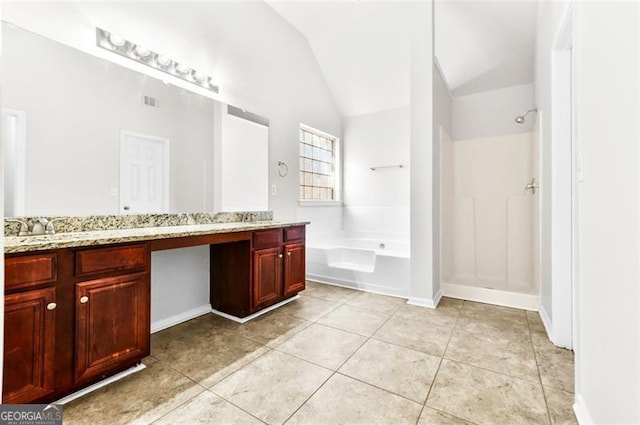 bathroom with a tub to relax in, vaulted ceiling, tile patterned floors, and vanity