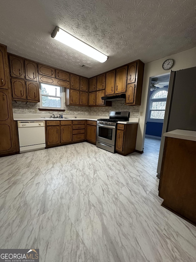 kitchen with sink, stainless steel gas range oven, and white dishwasher