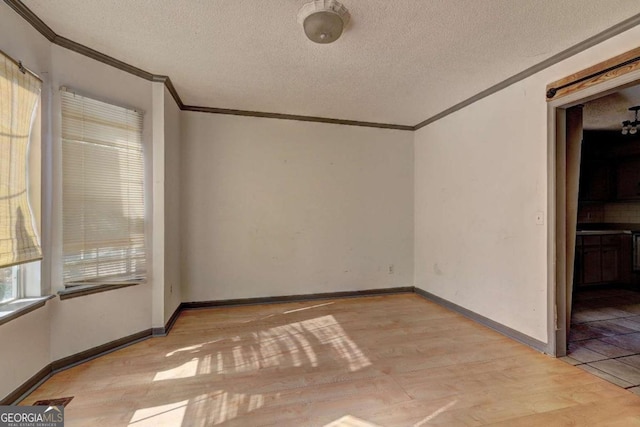 unfurnished room with a textured ceiling and ornamental molding