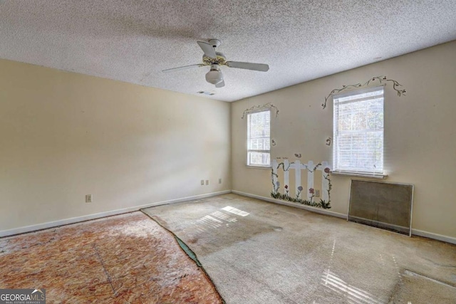 empty room featuring ceiling fan, a textured ceiling, and carpet flooring