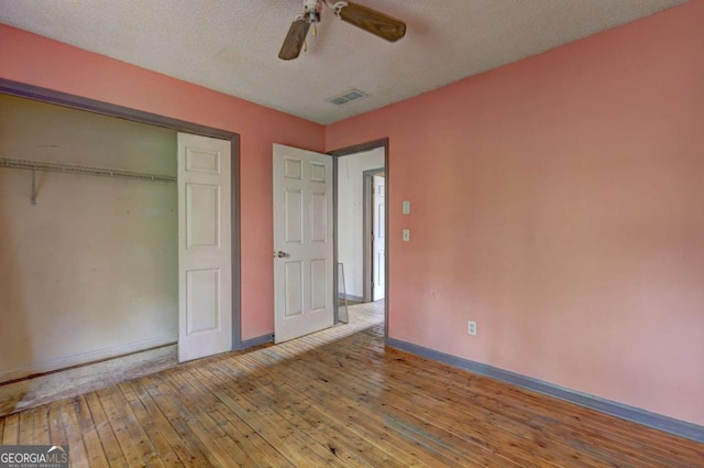 unfurnished bedroom featuring ceiling fan, wood-type flooring, a closet, and a textured ceiling