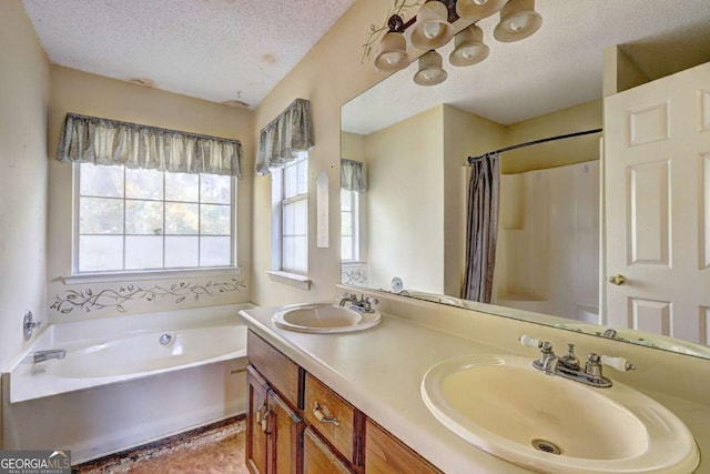 bathroom with a washtub, a textured ceiling, and vanity