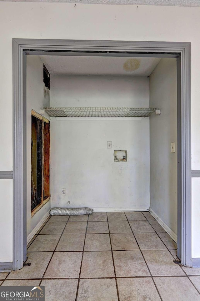 laundry area featuring washer hookup and light tile patterned floors