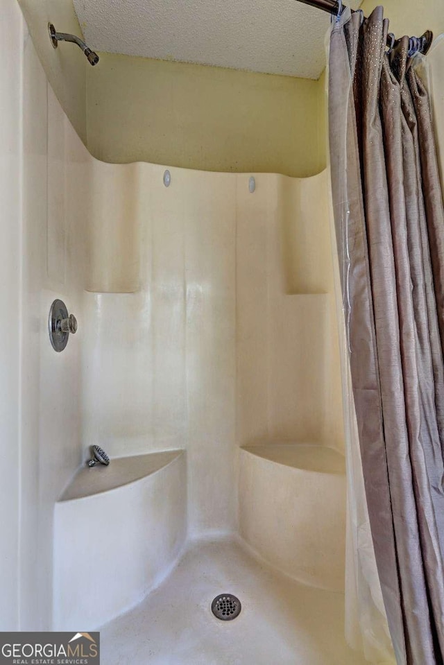 bathroom with a textured ceiling and a shower with curtain