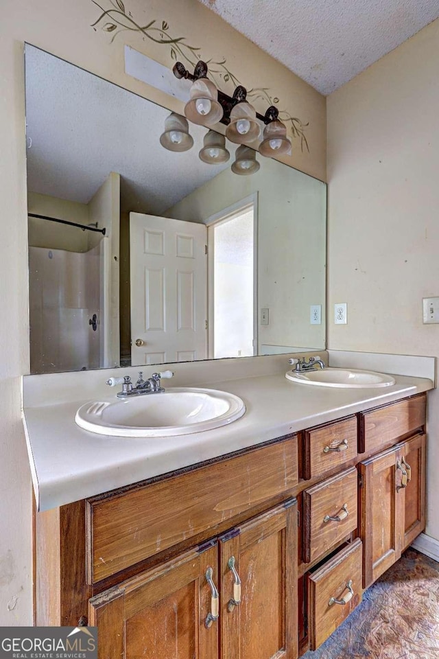 bathroom with vanity, a shower, and a textured ceiling