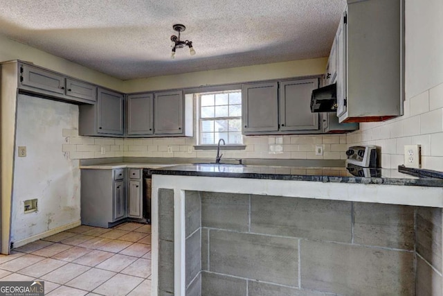 kitchen featuring a textured ceiling, extractor fan, light tile patterned floors, gray cabinetry, and sink