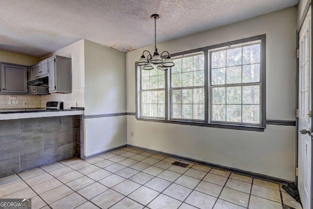 kitchen with a chandelier, hanging light fixtures, a textured ceiling, and tasteful backsplash