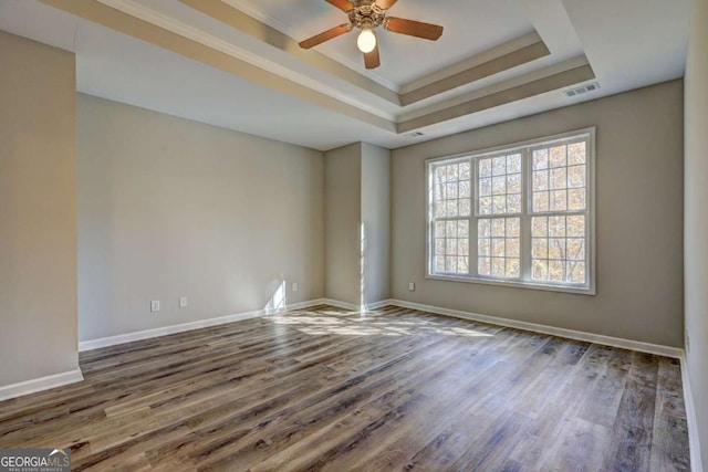 spare room featuring crown molding, hardwood / wood-style floors, ceiling fan, and a raised ceiling