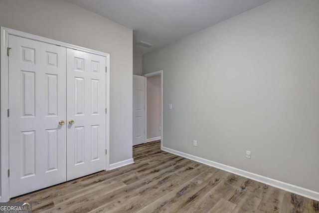 unfurnished bedroom featuring a closet and light wood-type flooring