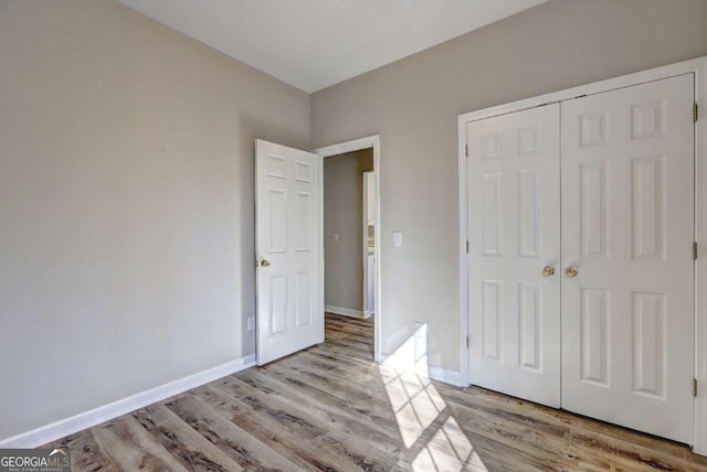 unfurnished bedroom featuring light wood-type flooring and a closet