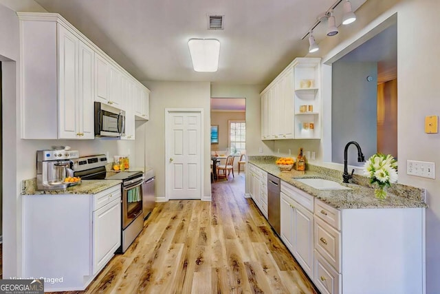 kitchen with light stone counters, sink, white cabinetry, and appliances with stainless steel finishes