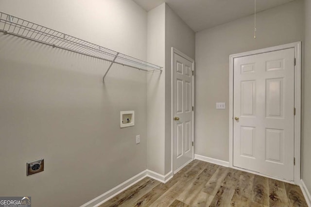 washroom with hookup for a washing machine, light hardwood / wood-style flooring, and electric dryer hookup