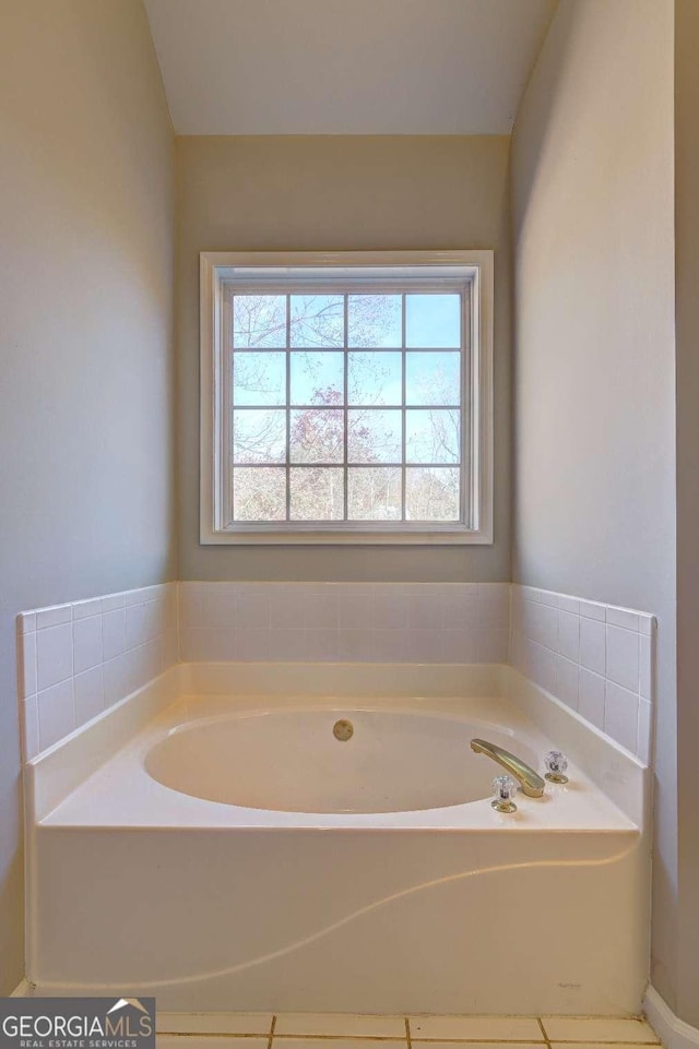 bathroom with plenty of natural light, tile patterned flooring, and a bathtub