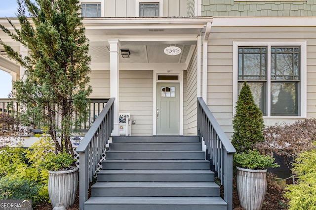 view of exterior entry featuring covered porch and board and batten siding