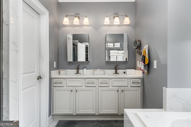 bathroom with double vanity, a bathing tub, and a sink