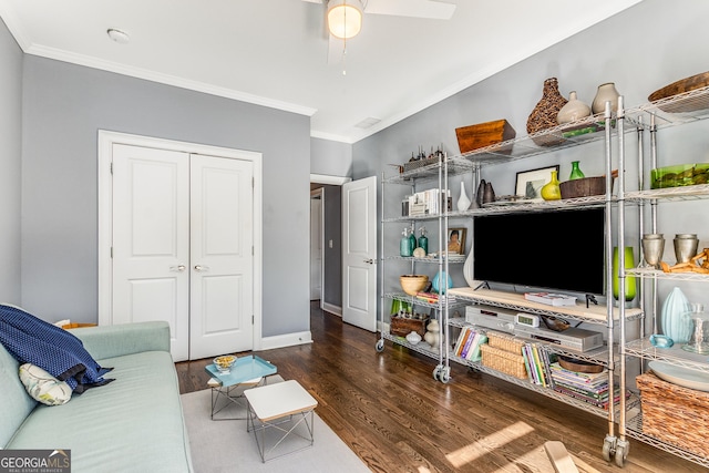 living area with wood finished floors, baseboards, and ornamental molding