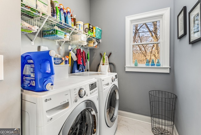 clothes washing area with baseboards, marble finish floor, laundry area, and washing machine and clothes dryer