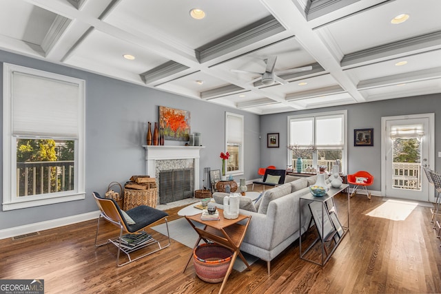 living room featuring visible vents, beam ceiling, a tiled fireplace, wood finished floors, and baseboards