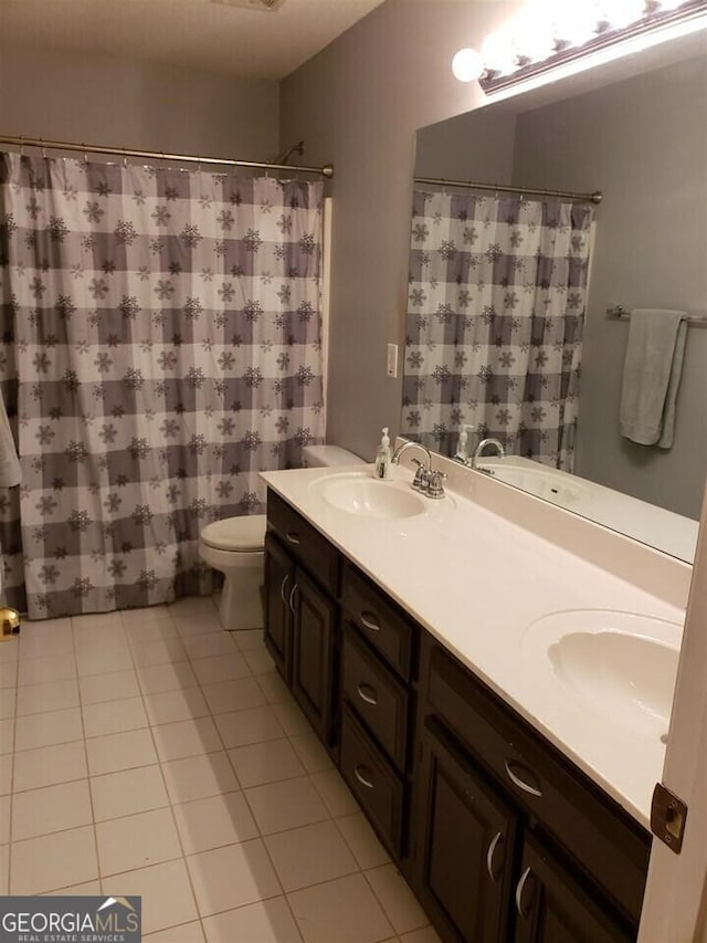 bathroom featuring toilet, tile patterned flooring, and vanity